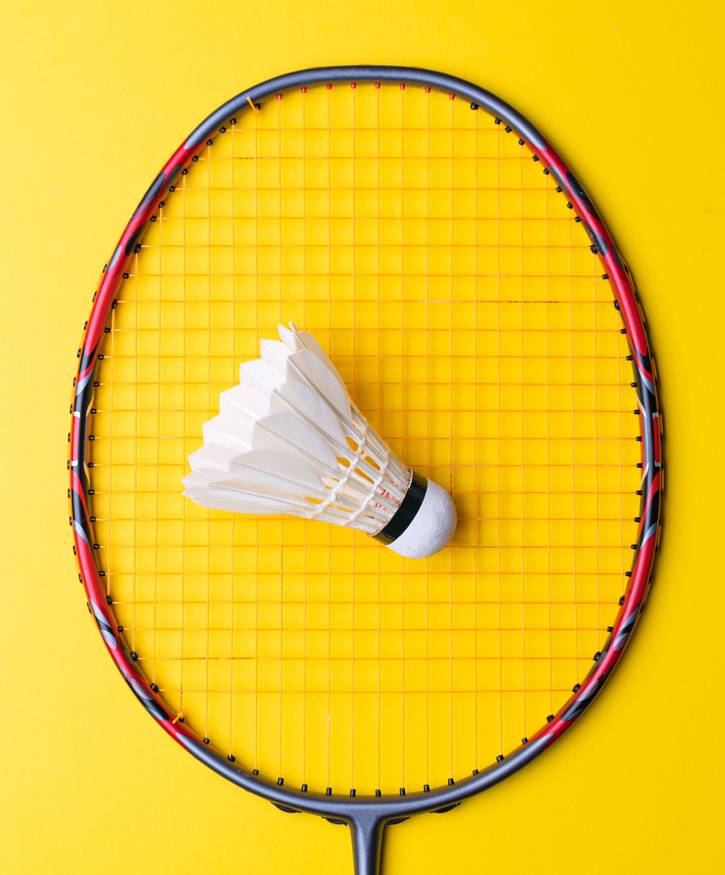 Badminton racket. Badminton racket from top-down. Badminton racket with shuttlecock on top. Badminton Racket with Red color accents.