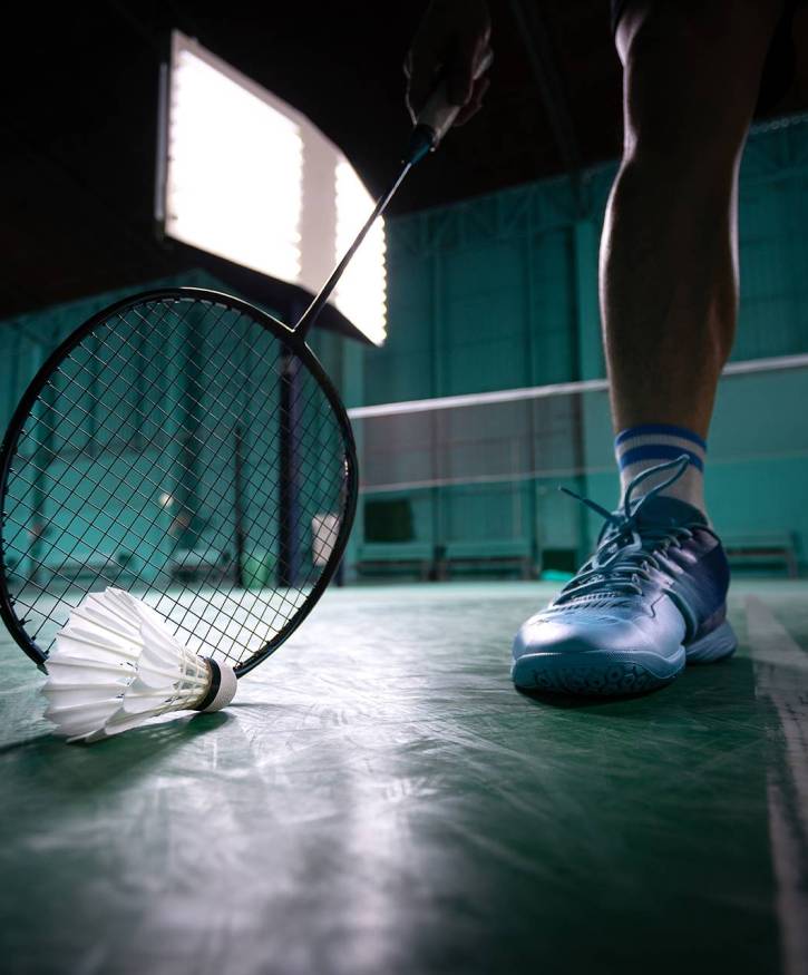 badminton ball or shuttle cock with badminton racquet in court with professional badminton player play in court at gym for healthy and sport championship competition