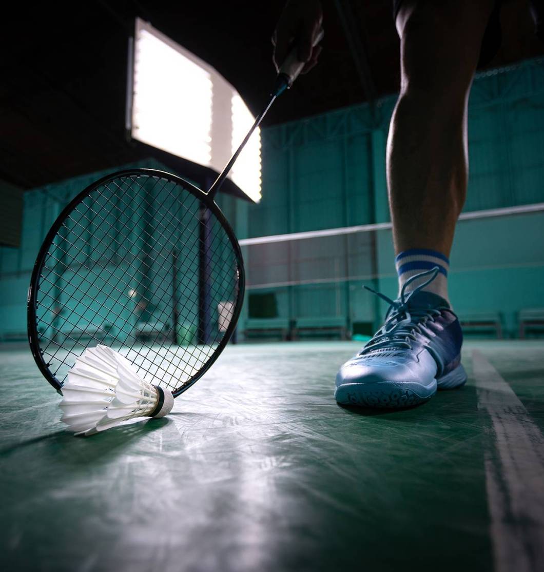 badminton ball or shuttle cock with badminton racquet in court with professional badminton player play in court at gym for healthy and sport championship competition